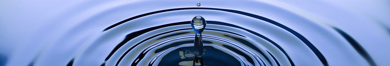 Drop of water in a rippling surface of blue